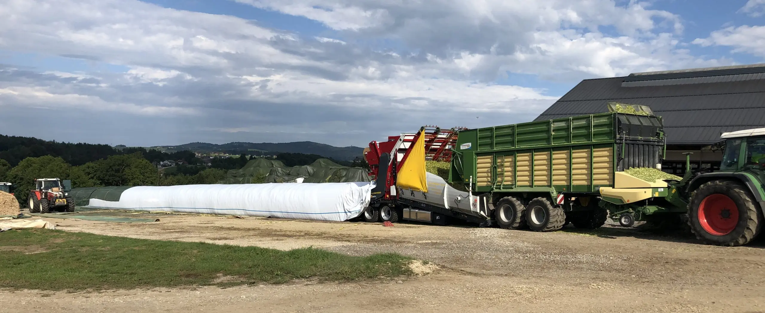 Landwirtschaftlicher Betrieb mit einem Traktor und einem Silospeed-System bei der Silage-Verarbeitung.