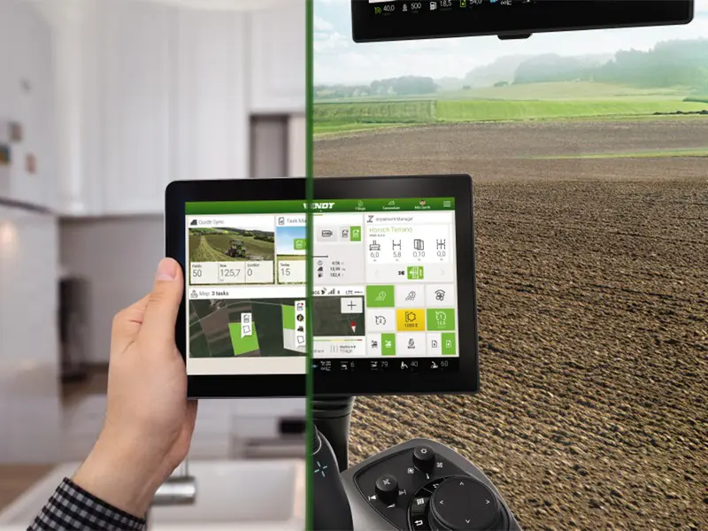 Hand hält Bildschirm von Fendt One, der landwirtschaftliche Daten zeigt; Hintergrund halb Büro, halb Acker.