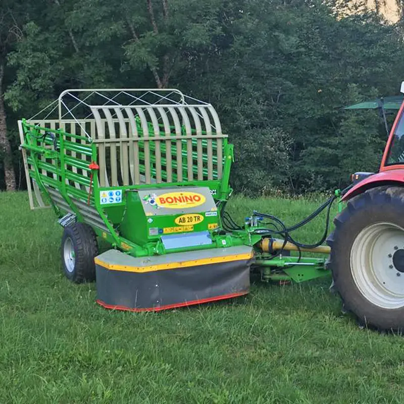 Grüner Bonino AB 20 TR angeschlossen an einen roten Traktor auf einer Wiese.