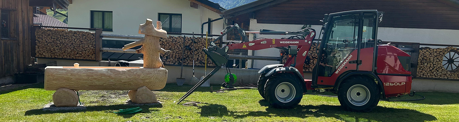 Der Weidemann 1260 LP vor einem Brunnen