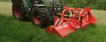 Traktor mit rotem Mähwerk der Marke Mauch mäht Gras auf einem Feld.
