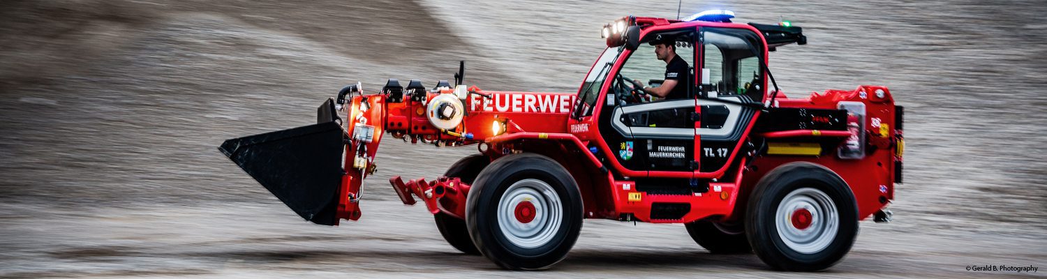Ein Feuerwehrfahrzeug Merlo 40.17 P von Mauerkirchen fährt auf einer Schotterpiste.
