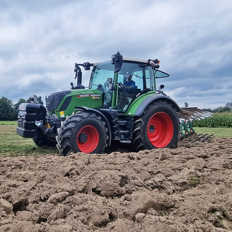 Traktor Fendt 314 pflügt ein Feld unter bewölktem Himmel.