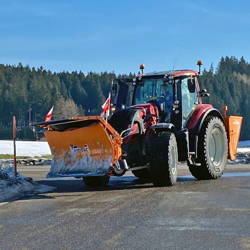 Valtra N-Serie Traktor mit Ruefa Schneepflug auf schneebedecktem Weg.