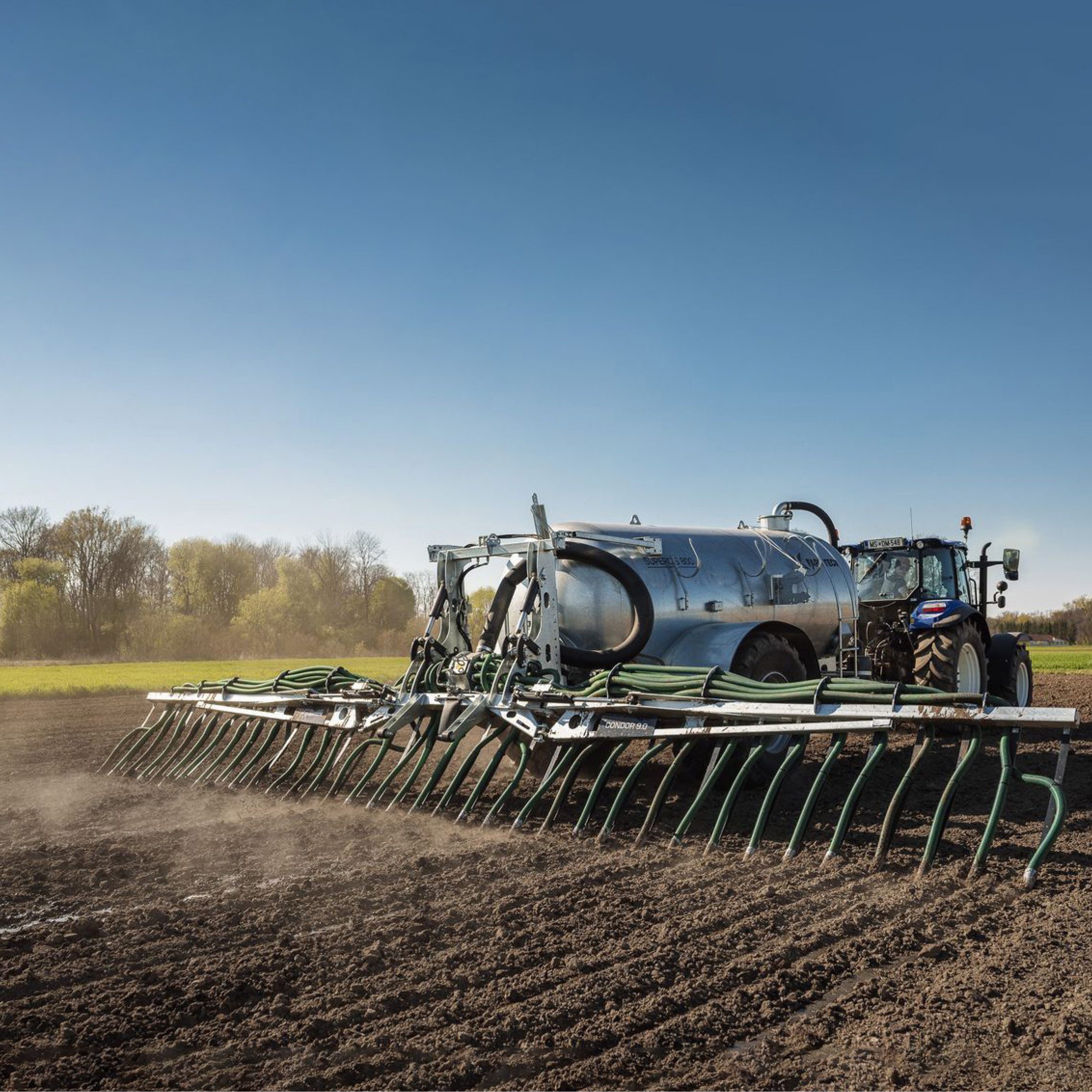Traktor, der ein Farmtech-Güllefass auf einem Feld zieht.