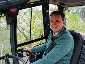 Doi adulți și doi copii privesc interiorul unui tractor Mauch.